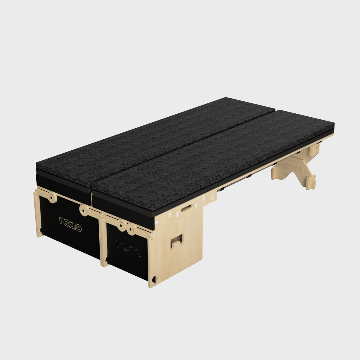 Modularer Schlafplatz aus Holz mit zwei schwarzen Matratzen, ideal für flexible Wohnlösungen.