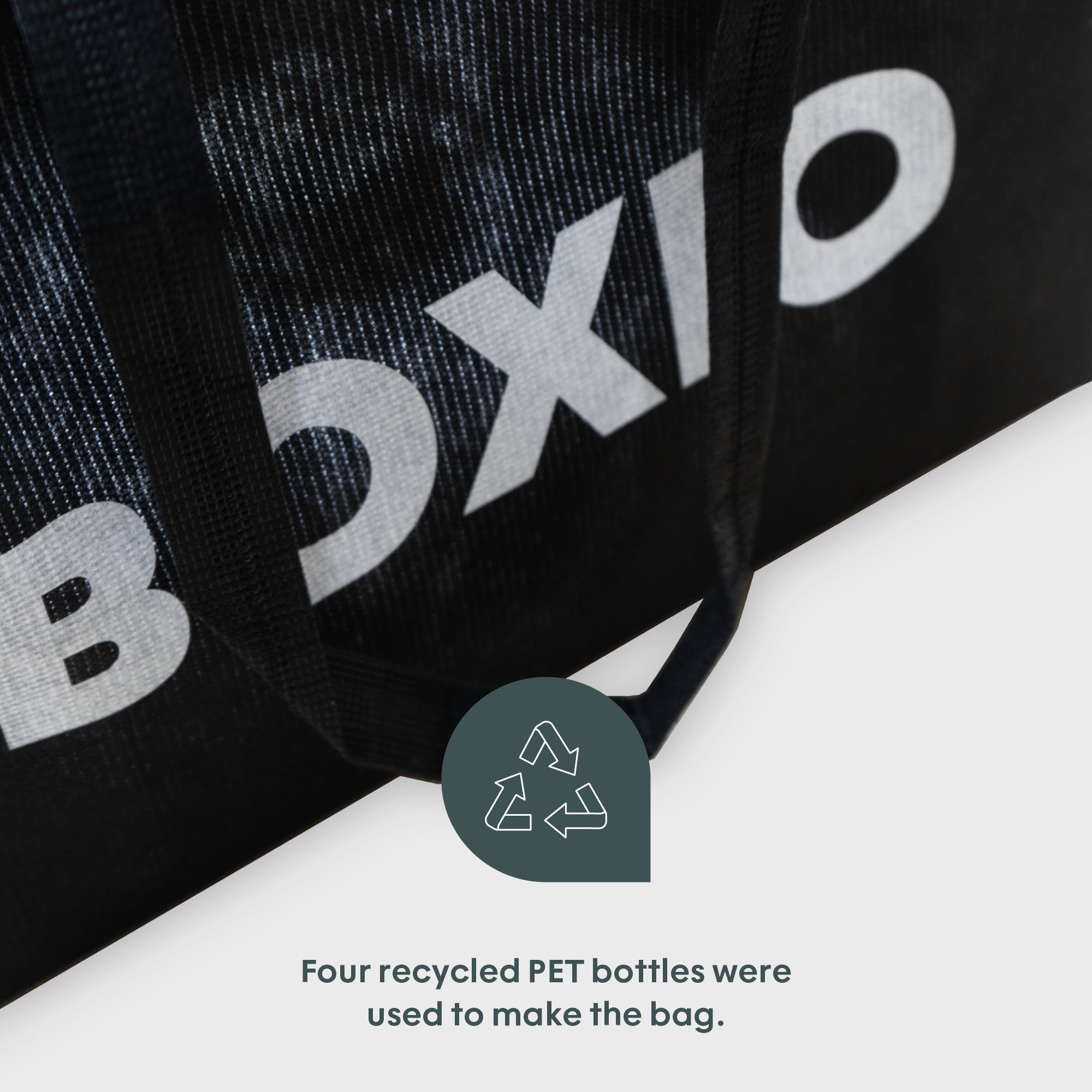 Schwarze Tasche mit dem Schriftzug "BOXIO", hergestellt aus vier recycelten PET-Flaschen.