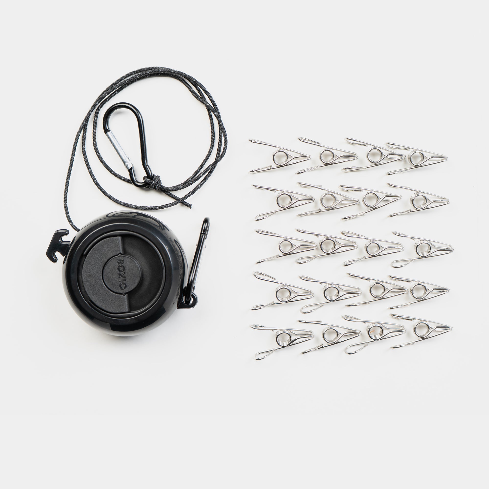 Schwarze Schnurrrolle mit Karabiner und 20 silbernen Wäscheklammern auf weißem Hintergrund.